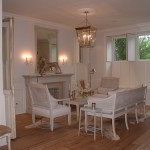 Elegant white living room furniture on wooden floor by fireplace